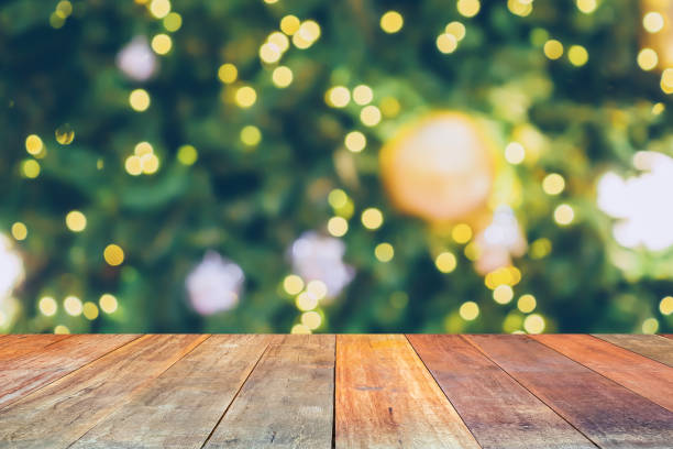 istock Empty wood table top with blur Christmas tree with bokeh light background 1450872303