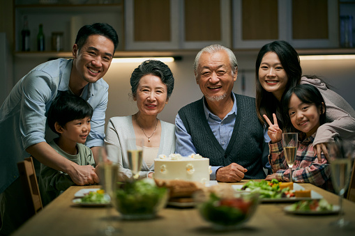 istock senior asian couple celebrating wedding annversary with three generational family 1450876011