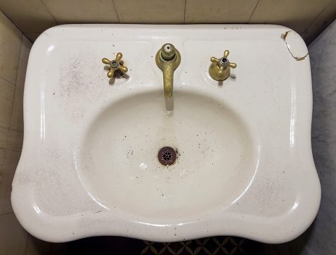 close up on dirty water sink and tap in bathroom