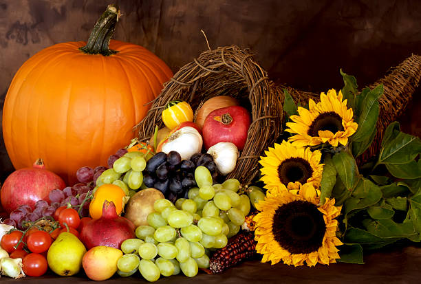 Thanksgiving Season Still life of Cornucopia full of fresh fruits and vegies, on a rich warm background, horiontial view abundance stock pictures, royalty-free photos & images