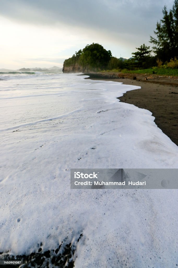 white waves and black sand the view of the white waves and black sand is very beautiful Aceh Stock Photo