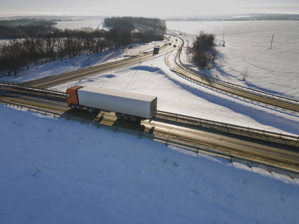 istock Lorry truck on the road surrounded by winter fields. 1450909835
