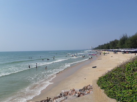 sea ​​water background with sandy beach and people playing in the sea in the area of ​​Cha-am district Phetchaburi, Thailand