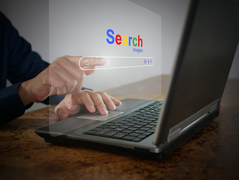 Un hombre está usando una computadora portátil para buscar información. Una pantalla virtual del navegador del sitio web de búsqueda para encontrar datos en Internet. Red global, tecnología de optimización de motores de búsqueda photo