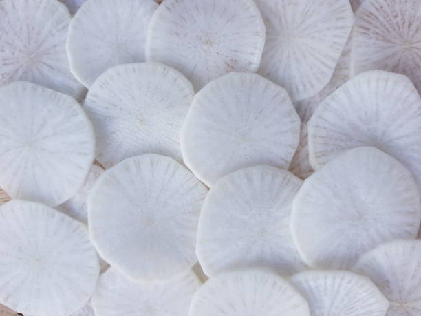 istock white radish slices on wood background. 1450929767