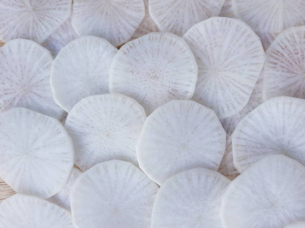 istock white radish slices on wood background. 1450929771