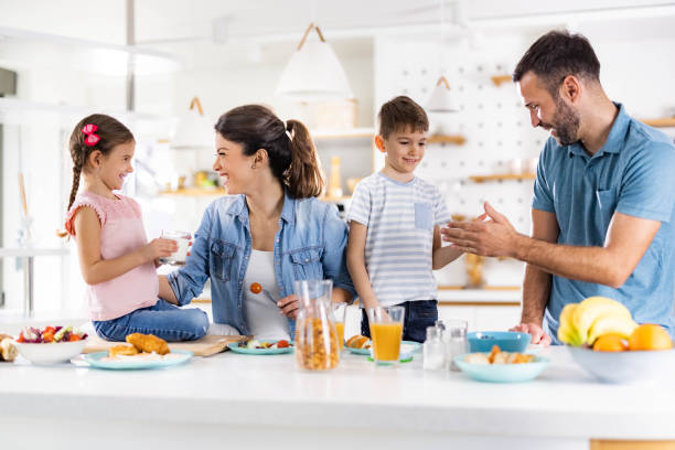 istock Happy family having breakfast in dining room. 1450936315