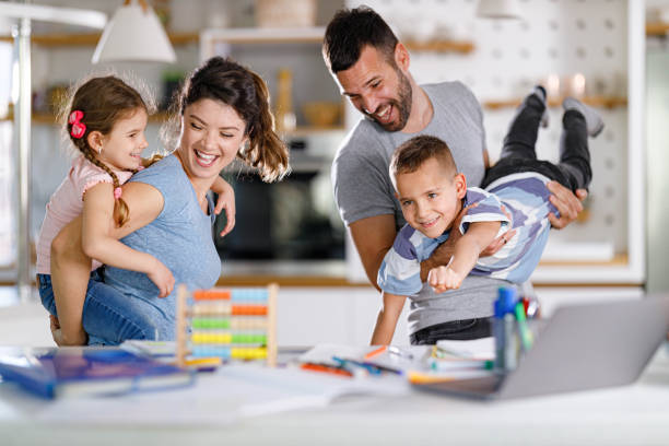 istock Cheerful parents having fun with their kids at home. 1450937571