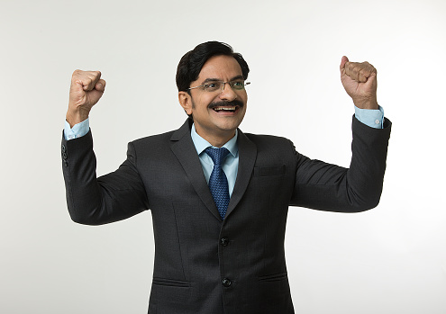 Cheerful businessman pumping fist and celebrating success