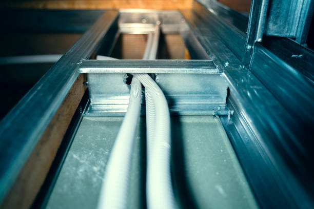 istock A corrugated pipe with wires passes through a metal profile in a plasterboard frame wall. Wiring inside the interior partition. Protective insulation of electrical wires 1450945156