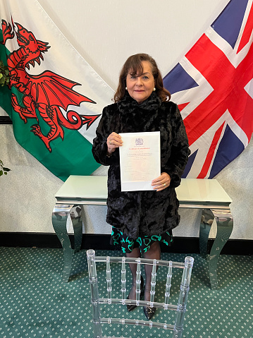 Senior Hispanic woman with British Naturalization certificate