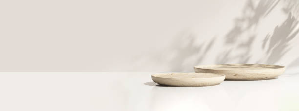 istock Two minimal modern wooden round tray podium on white glossy table counter in dappled sunlight, leaf shadow on wall 1450954842