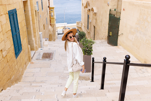 Fashionable young woman exploring old Mediterranean town