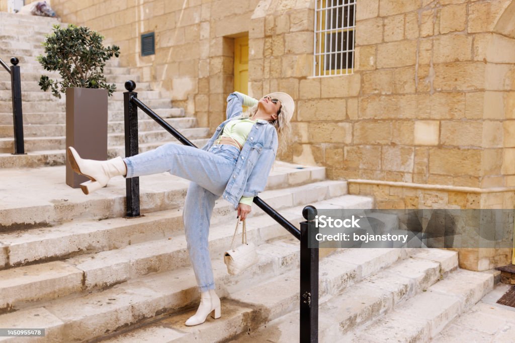 Woman in Mediterranean passage alley Stylist young woman standing and posing on stone staircase in old town on sunny day Adult Stock Photo