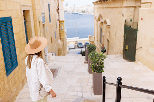 Fashionable young woman exploring old Mediterranean town