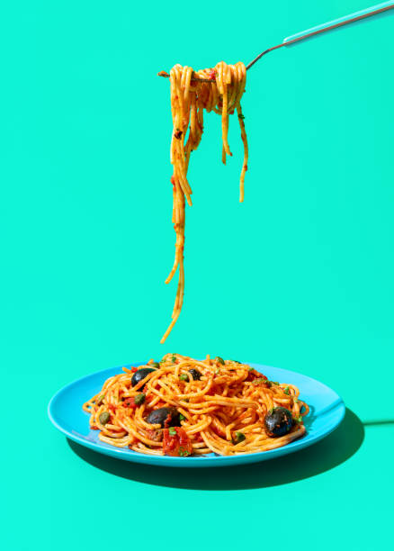 istock Eating italian spaghetti from a plate, isolated on a green background 1450956912