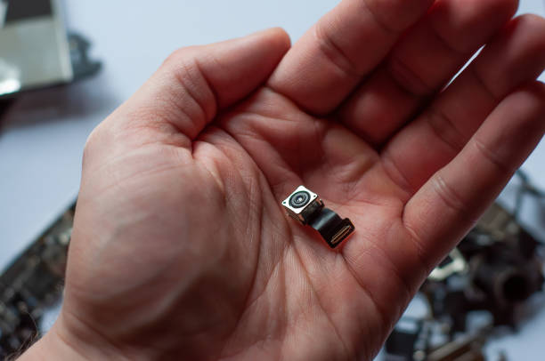 istock Square module of a small camera with a loop for connection in the palm of your hand. 1450960555