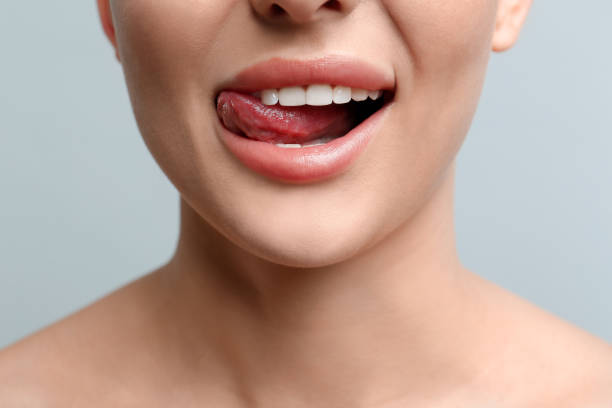 istock Woman licking her lips on light background, closeup 1450962824
