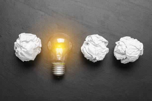 istock Creative flat lay composition with lightbulb and paper balls on black table. Idea concept 1450964160