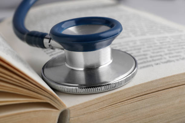 istock Open student textbook with and stethoscope, closeup. Medical education 1450966490