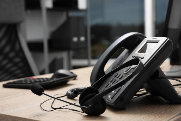 istock Stationary phone and headset on wooden desk indoors. Hotline service 1450966607