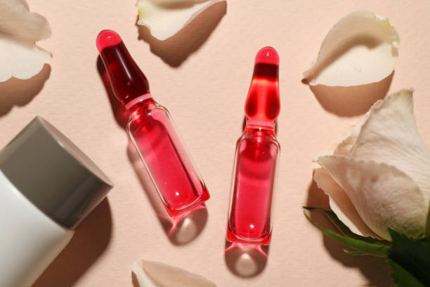 istock Pharmaceutical ampoules with medication, bottle and flower on pink background, flat lay 1450966795
