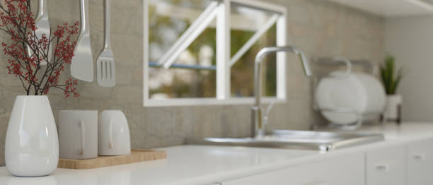 istock Modern white kitchen counter against the grey wall with window, sink and kitchenware 1450966983