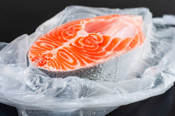 istock Big salmon steak in an open bag on a black background 1450967571