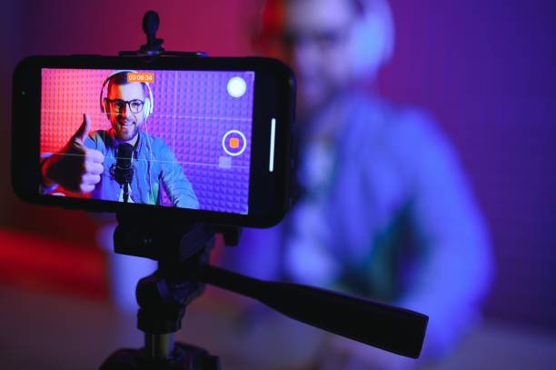 istock Young man recording or streaming podcast using microphone at his small broadcast studio. Content creator. 1450968523