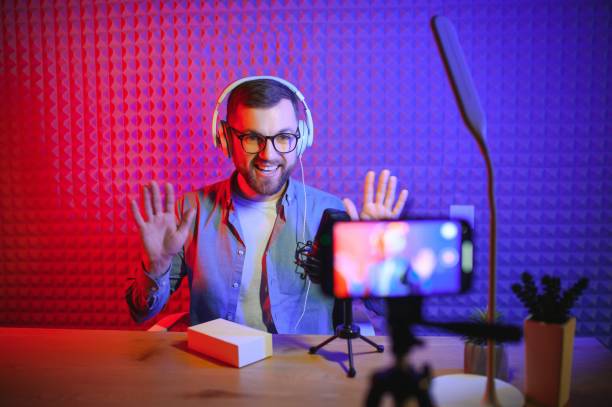 istock Young man recording or streaming podcast using microphone at his small broadcast studio. Content creator. 1450969550