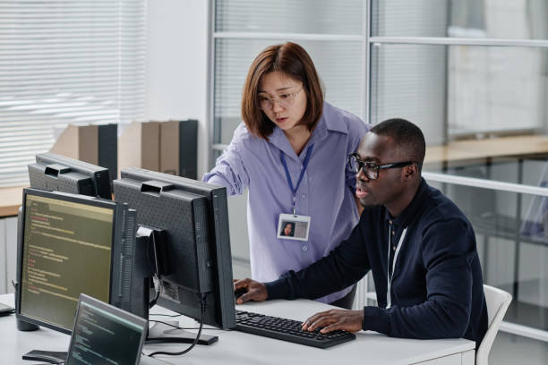istock Woman discussing new software with colleague 1450969767