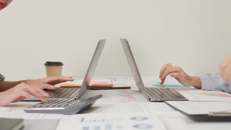 Closeup group of Asian business people meeting discuss project plan and financial results in office. Marketing strategy analysis, stock market trading, financial consultant.