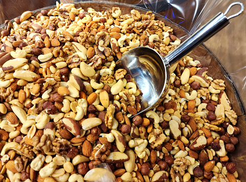 Full bowl of different kinds peanuts, nuts and seeds