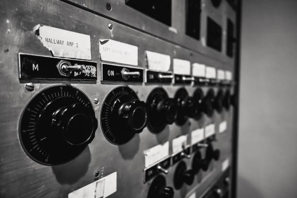 A closeup of switches and knobs on an antique control panel