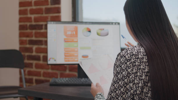 istock Close up of person analyzing data charts on files 1450974086