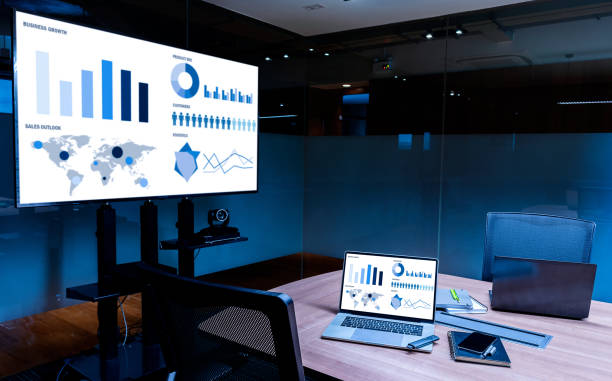 istock Slide show presentation on display television and laptop with notebook on table in meeting room 1450974638