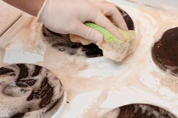 istock The process of washing a stove heating element with a sponge and a rubber glove 1450974953