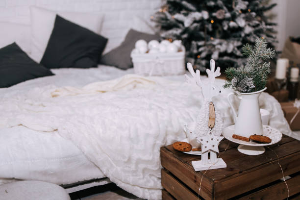 istock Cozy Christmas interior with bed and marshmallow in the white cup with sweets and decorations on the table 1450977533