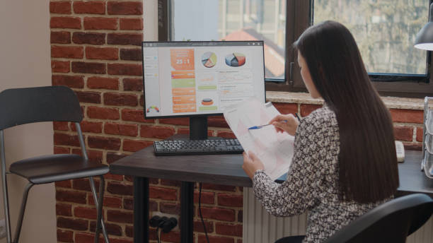 istock Close up of employee working with charts on papers 1450978967
