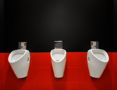 Three public male pissoirs in a public toilets
