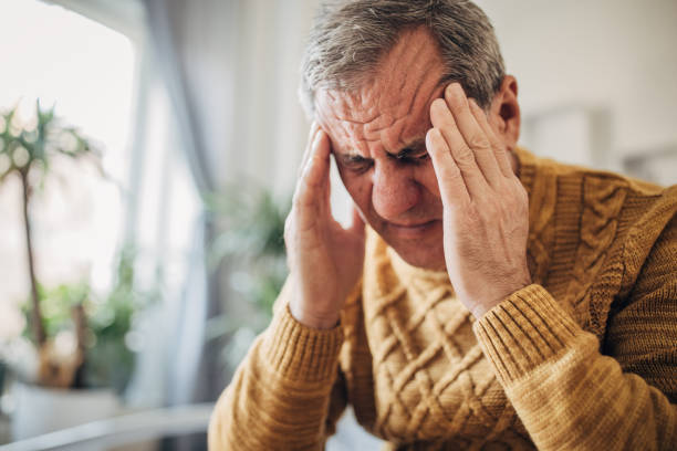 istock Headache, a man massages his head with his hands 1450981173
