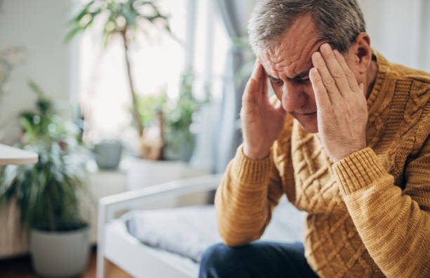istock Headache, a man massages his head with his hands 1450981178