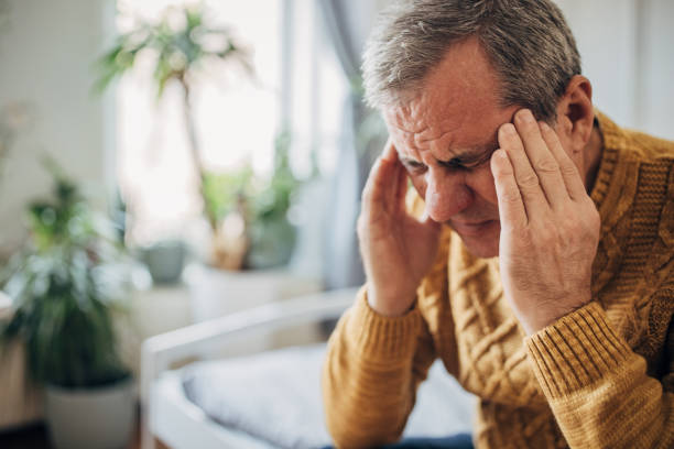 istock Headache, a man massages his head with his hands 1450981820