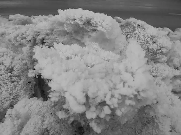 Retro image - Massive heap of snow dirty from fumes piled up next to the road and covered by beautiful hoarfrost ice crystal structures resembling corals.