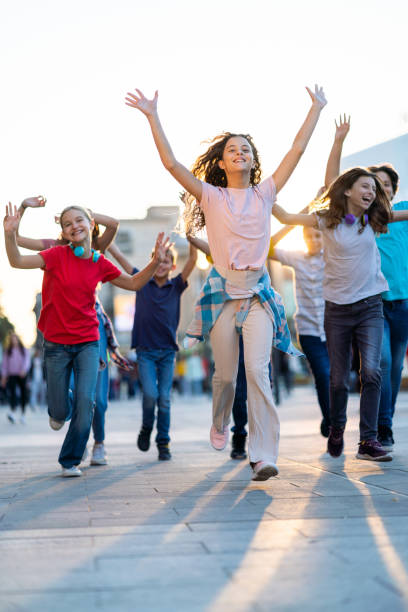 istock Group of happy children running on city street 1450993473
