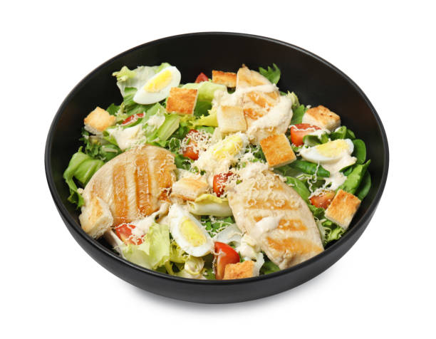istock Delicious Caesar salad in bowl isolated on white 1450995249