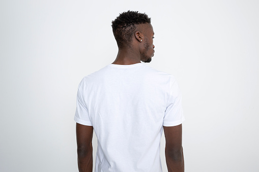 Hombre afroamericano con camiseta blanca sobre fondo blanco. photo