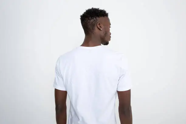 Photo of African-American man in white t-shirt against white background.