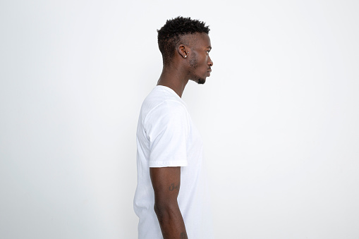 African-American man in white t-shirt against white background.