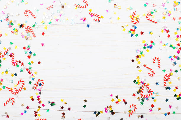 istock Christmas background with candy canes and multicolored sequins on blue wooden background 1450998975